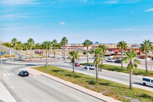 a street with palm trees and cars on the road at Velapi 23 in Roda