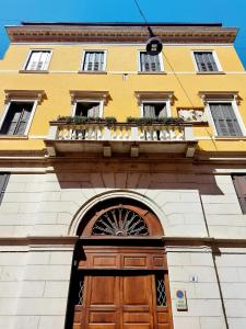 a yellow building with a wooden door and a balcony at Mario Number 8 in Verona