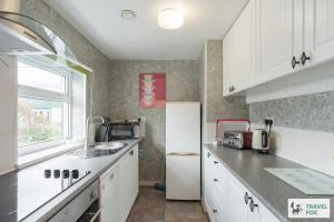 a kitchen with a refrigerator and a sink at Birchenfield Holiday Cottages in Dilhorne