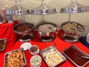 a buffet of food on a red table at Thara Beach Resort in Kampong Pasir Bogak