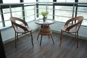 two chairs and a table in a room with a window at Hotel Elite Executive Lodging in Bārāmati