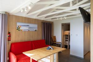 a living room with a red couch and a table at Bungalows Portuondo parking gratuito in Mundaka