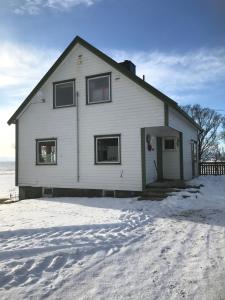 a white house in the snow with its door open at Tenant Farm House in Dverberg