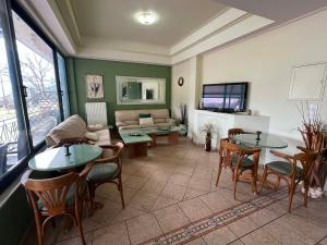 a living room with tables and chairs and a couch at Filoxenia Marias in Loutra Ipatis