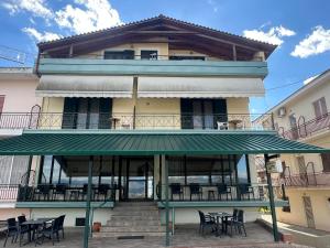 a building with tables and chairs in front of it at Filoxenia Marias in Loutra Ipatis