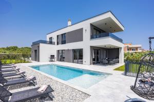 a villa with a swimming pool and a house at Villa Delecto in Premantura