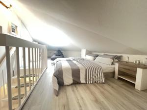 a white bedroom with a bed and a wooden floor at LT35a Haus Sternengucker in Dorum-Neufeld +10 photos