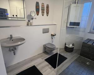a bathroom with a toilet and a sink and a shower at LT35a Haus Sternengucker in Dorum-Neufeld