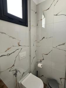 a bathroom with a toilet and a window at Ambelas Getaways in Himare