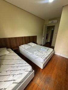 zwei Betten in einem Zimmer mit Holzboden in der Unterkunft Hotel Moraes próximo a 25 de Março, Brás e Bom Retiro - Reserve agora e só pague no check-in in São Paulo + 62 Fotos