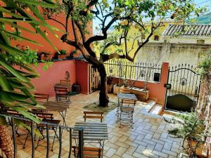 a patio with tables and chairs and a tree at La Perla del Sud in Teulada