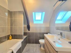a bathroom with a sink and a toilet and skylights at Ty Coët, plage et Golfe à pieds in Arradon