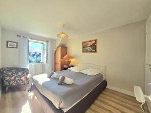 a bedroom with a bed and a chair and a window at Ty Coët, plage et Golfe à pieds in Arradon +7 photos