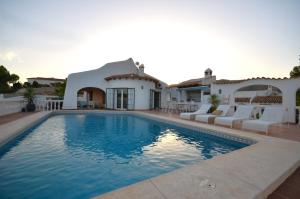 a villa with a swimming pool in front of a house at Villa Cala Lanuza in Alicante