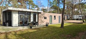 a small house in a yard with a tree at Casa Bosrust - Luxe, rust, natuur en privacy in Haarle