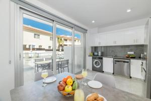 a kitchen with a table with a bowl of fruit on it at Rons House in Paralimni
