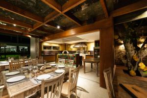 a dining room with a large wooden table and chairs at Hotel Pontal de Ubu in Anchieta