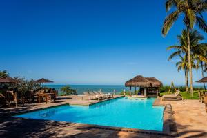 a swimming pool with a view of the ocean at Hotel Pontal de Ubu in Anchieta