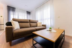 a living room with a couch and a table at Flex SelfCheckIns 99 - 2 Bedrooms - Parking - Loggia in Velika Mlaka