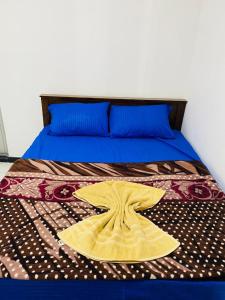 a bed with a yellow blanket on top of it at Three D Rooms in Haldummulla