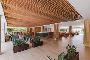 a lobby of a hotel with chairs and plants at Rio Quente Resorts Refúgio Grand Premium - Antigo Hotel Turismo in Rio Quente