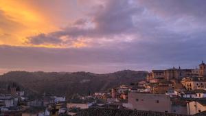 a view of a city at sunset with buildings at Torreón del Vicario in Toledo