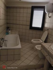 a bathroom with a tub and a toilet and a window at Nonna Maria Bed and Breakfast in Caserta