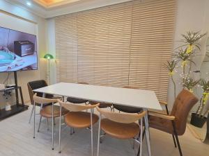 a dining room with a white table and chairs at Daegu-station 동성로 GoodLuck STAY in Daegu