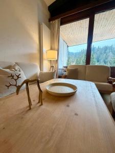 a living room with a table and a couch at HappyLaax - Panoramic Penthouse - Pool, Sauna & Private Parking in Laax