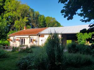 a house with a metal roof in a garden at Logis51 in Ville-sur-Tourbe