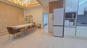 a kitchen with a dining table and a refrigerator at Daegu-station 동성로 GoodLuck STAY in Daegu