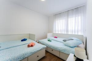 a bedroom with two beds and a window at Flex SelfCheckIns 99 - 2 Bedrooms - Parking - Loggia in Velika Mlaka +38 photos