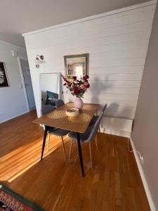 a dining room table with a vase of flowers on it at Stylish 2-bedrooms apartment, smart TV, Netflix, parking - Oslo in Oslo +20 photos