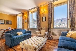 a living room with blue furniture and a large window at Casa Orta appartamento con vista lago in Orta San Giulio