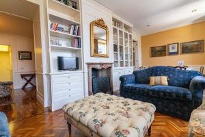 a living room with a blue couch and a tv at Casa Orta appartamento con vista lago in Orta San Giulio