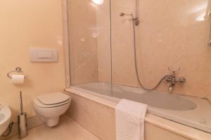a bathroom with a tub and a toilet and a shower at Casa Orta appartamento con vista lago in Orta San Giulio +11 photos