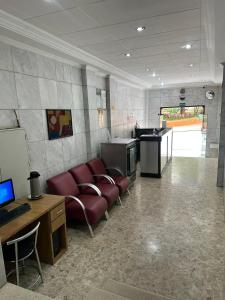 ein Wohnzimmer mit Sofa, Schreibtisch und Computer in der Unterkunft Hotel Moraes próximo a 25 de Março, Brás e Bom Retiro - Reserve agora e só pague no check-in in São Paulo