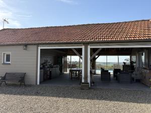 a pavilion with a patio with a table and chairs at Les vergers d'Anjoy in Montesquieu