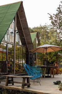 a house with a picnic table and chairs and an umbrella at Cabaña Romántica, glamping Piedra Braza Orígenes in Ocoyoacac