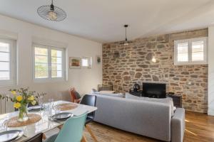 a living room with a stone wall and a table and chairs at P'ty Solidor - 500m du port in Saint Malo