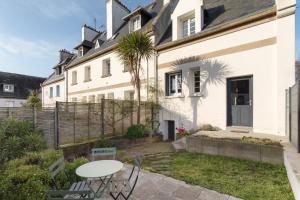 a white house with a table and chairs in the yard at P'ty Solidor - 500m du port in Saint Malo