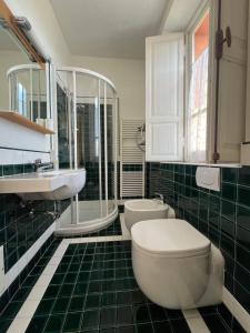 a bathroom with a toilet and a sink and mirror at Hotel Liberty in Pattada