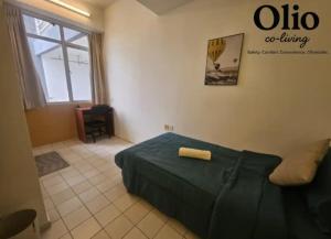 a bedroom with a bed with a green comforter at Olio CoLiving Pudu Kuala Lumpur in Kuala Lumpur
