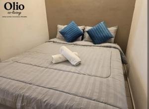 a bed with blue and white pillows on it at Olio CoLiving Pudu Kuala Lumpur in Kuala Lumpur