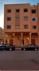 two cars parked in front of a building at Licht & ruim 2-slaapkamer appartement met airco & Wifi - rustig wijk Marrakesh in Marrakesh