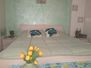 a bedroom with a large bed with a vase of flowers at La Rosa Verde in Castrovillari