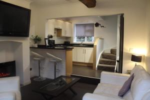 a living room with a white couch and a kitchen at Yarm View Guest House and Cottages in Yarm