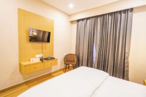 a hotel room with a bed and a television at Hotel American inn in Nakodar