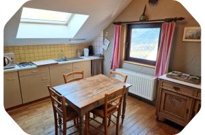 a kitchen with a table and chairs and a window at Gîte 2 pers - La Pommeraie - Le Coin Ardenne in Sainte-Ode