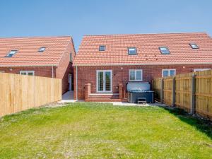 a house with a fence in front of a yard at Dawson Park 8 - Uk12667 in Mablethorpe
